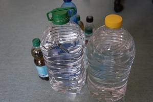 zdjęcie przedstawia: leżące na podłodze butelki z alkoholem niewiadomego pochodzenia