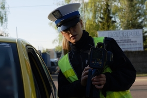 zdjęcie przedstawia: policjantka ruchu drogowego pokazująca na urządzeniu prędkość
